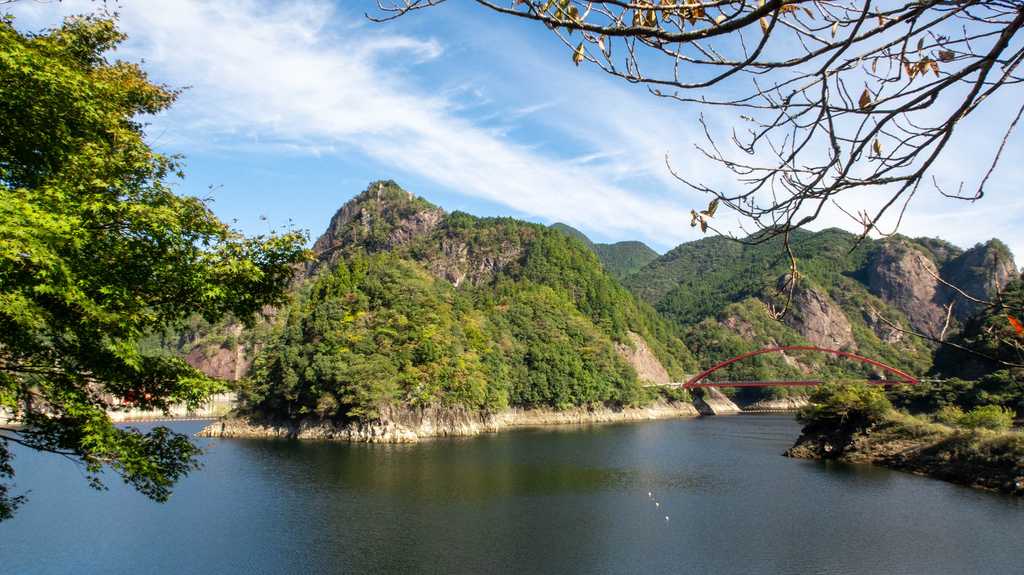 木々の間から望むダム湖と奇岩