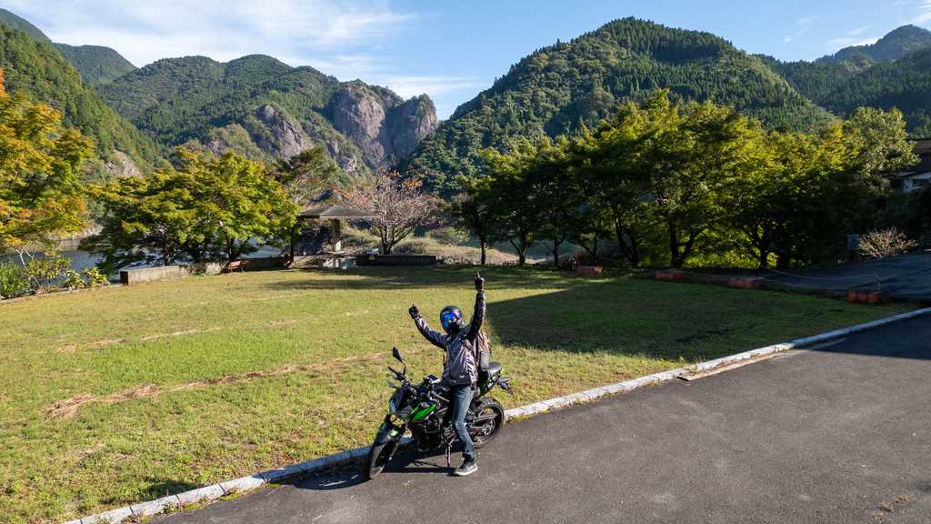 奇岩をバックに愛車とガッツポーズ